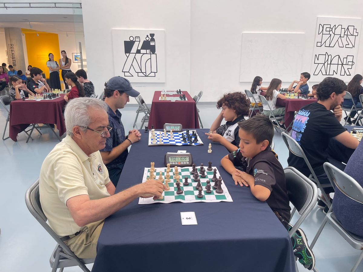 Adulto y niño jugando ajedrez en el 1er Torneo Chess Champions México